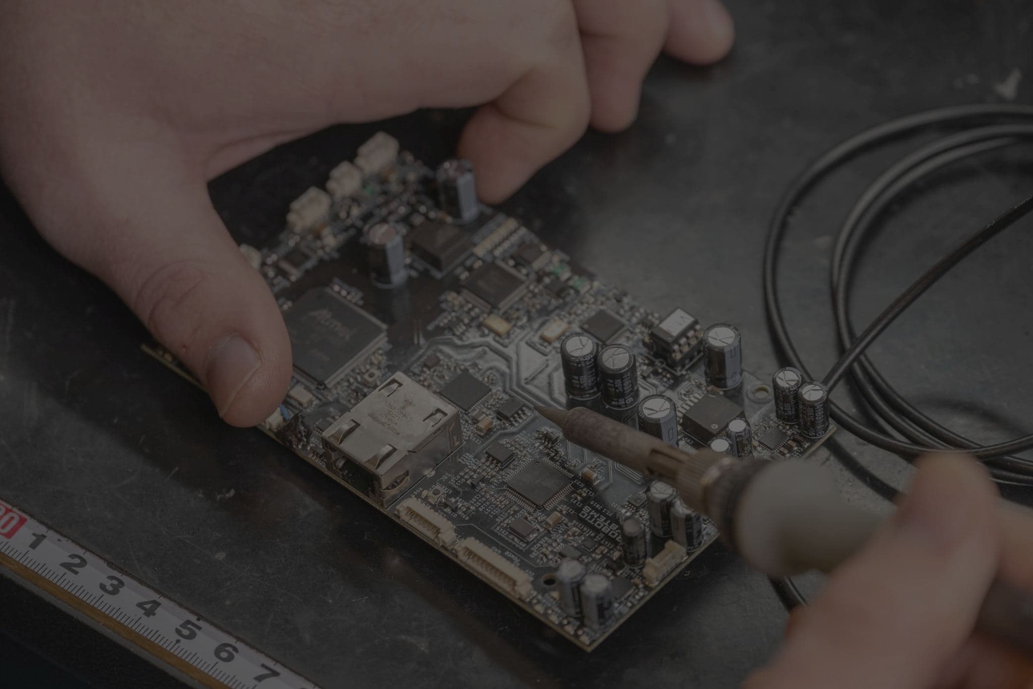 Hands soldering a Robotic Systems circuit board on the workbench